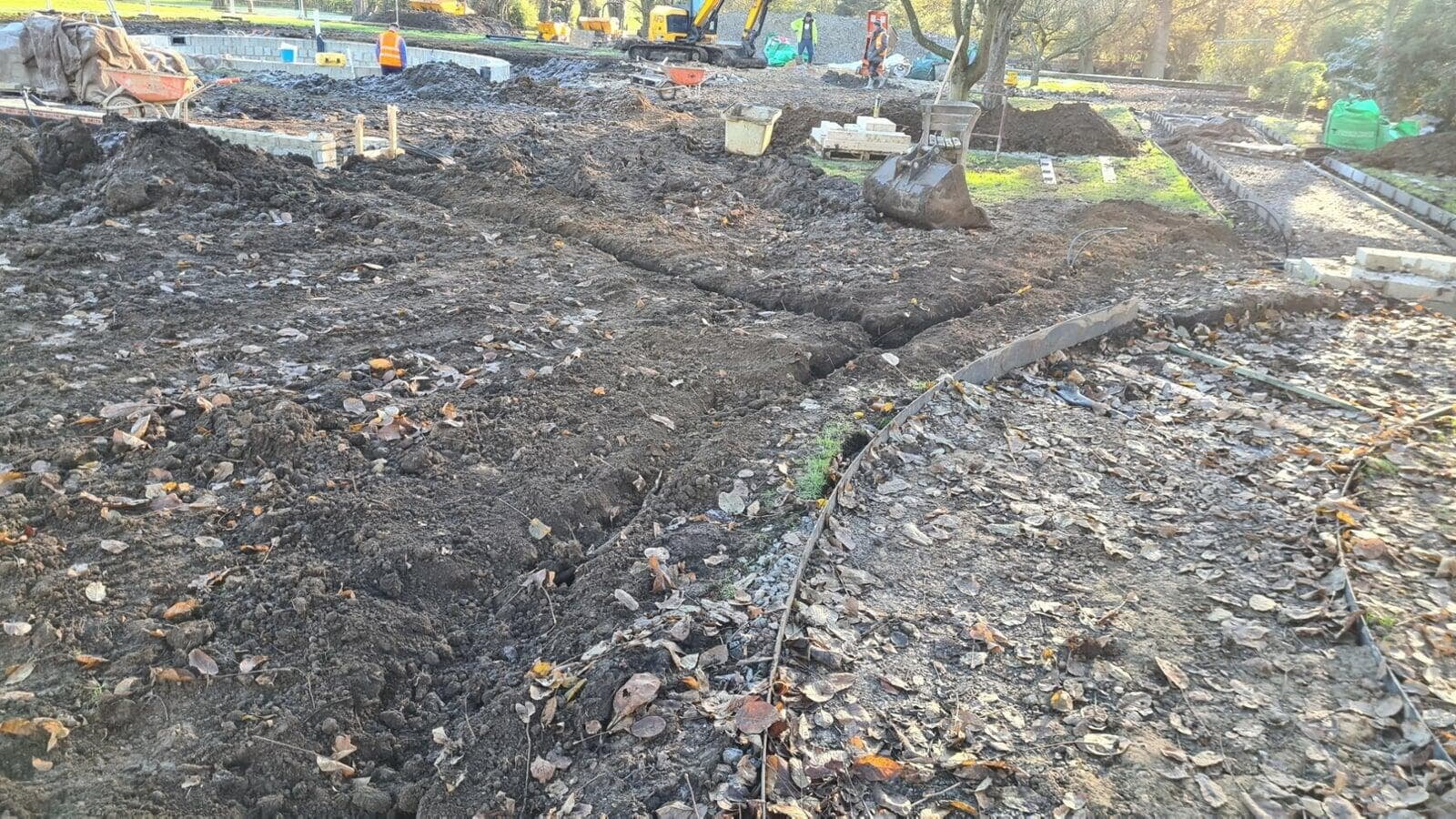 Trenches backfilled with irrigation pipes near the path edge
